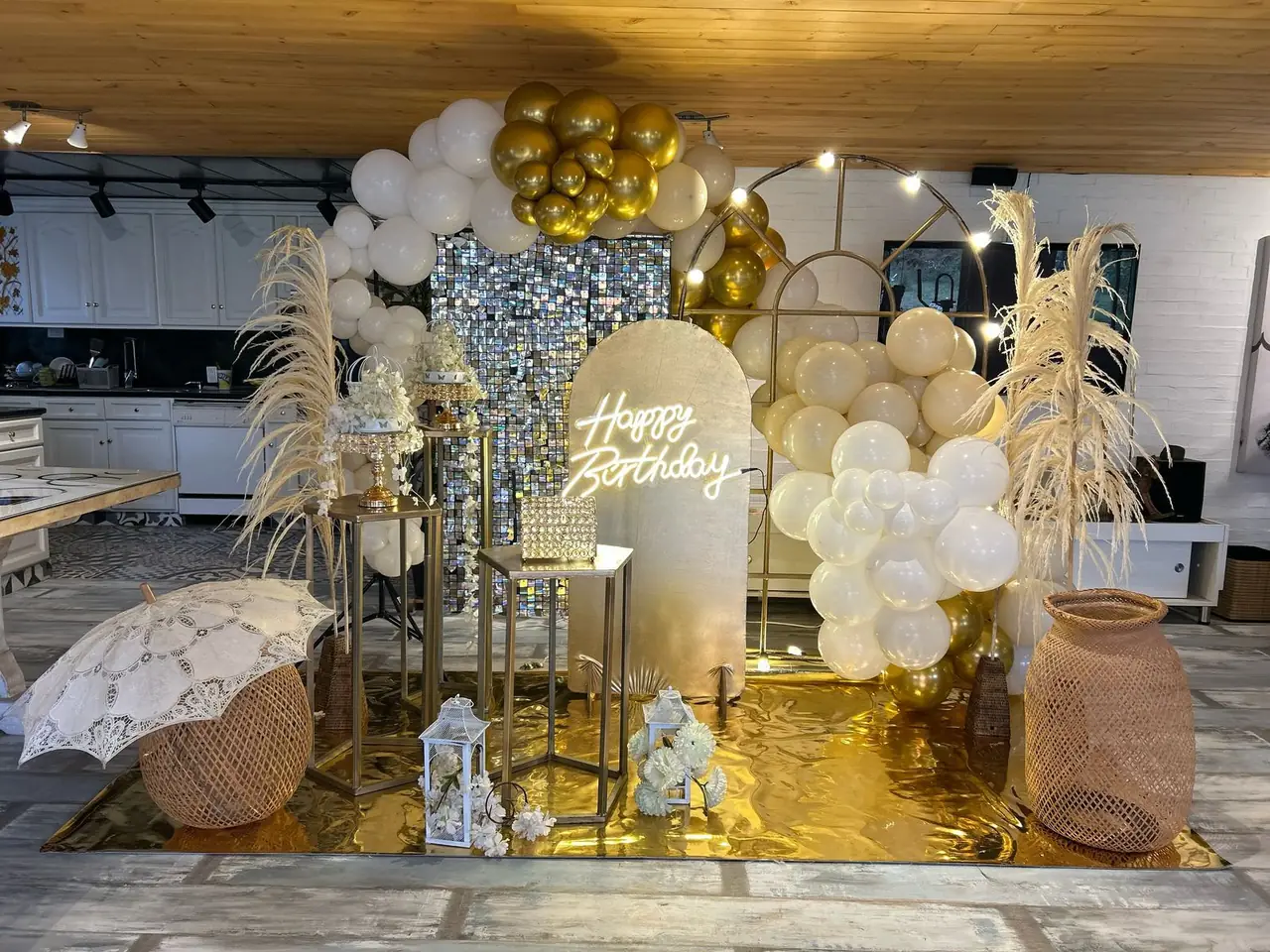Decoración de cumpleaños en dorado y blanco con arco de globos