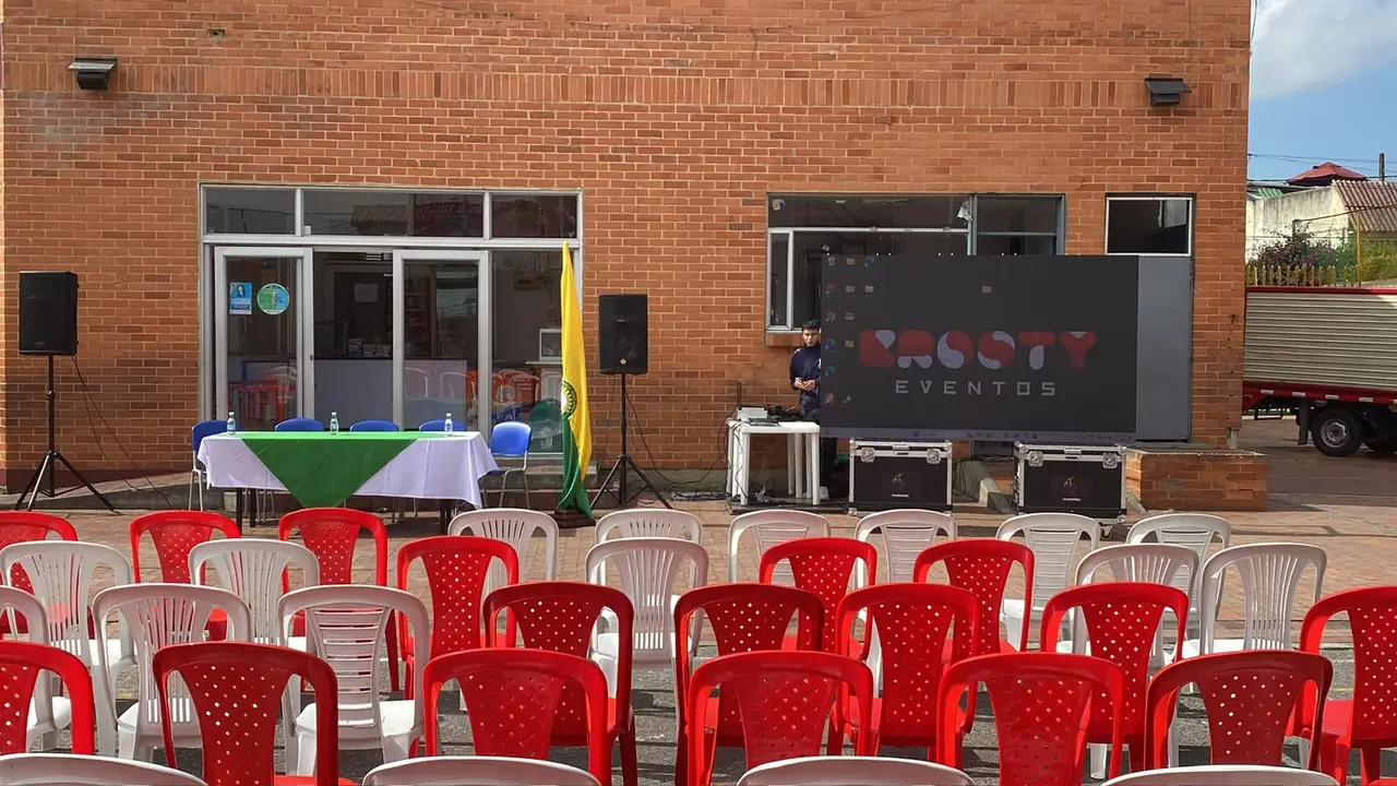 Montaje institucional con sillería y pantalla con logo Krosty